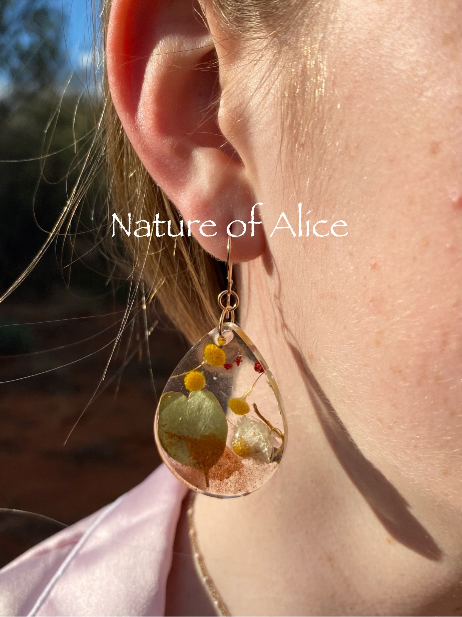The Red Centre earrings, teardrop, gold, heart leaf mallee eucalypt, white paper daisy, billy button, nodding saltbush red berry, red dirt, Alice Springs, Central Australia.