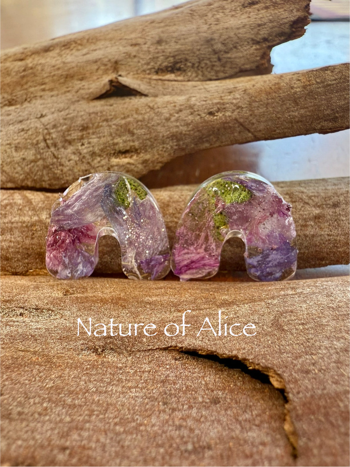 Sturt's Desert Rose Resin earrings with natural elements on a bark background, featuring 'Nature of Alice' branding.